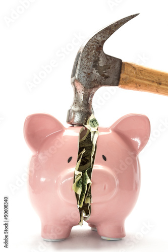 Photo: Piggy bank with money inside and hammer over Piggy bank with money inside and hammer over