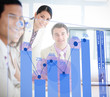 Smiling business workers looking at blue chart interface