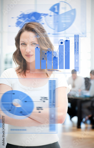 Photo: Confident businesswoman using chart interfaces Confident businesswoman using chart interfaces