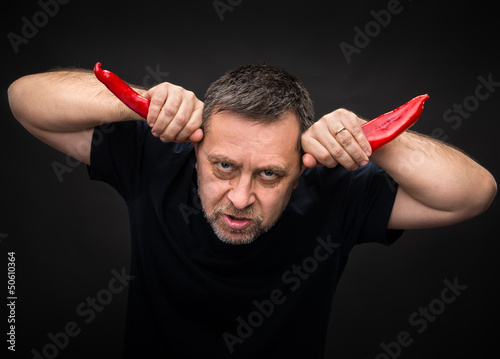 Photo: elderly man holding two red hot chili peppers elderly man holding two red hot chili peppers