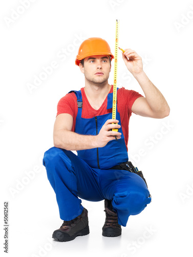 Photo: Construction worker measuring the wall Construction worker measuring the wall