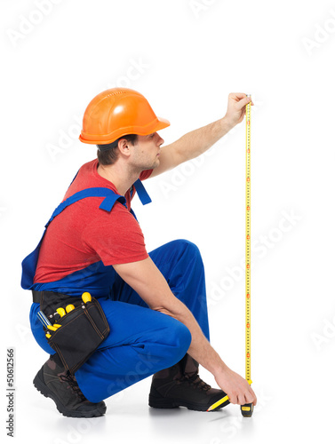 Photo: Construction worker measuring the wall Construction worker measuring the wall