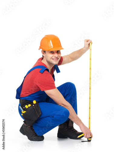 Photo: Construction worker measuring the wall Construction worker measuring the wall