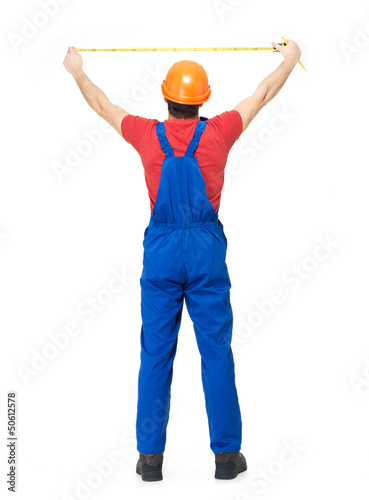Photo: Construction worker measuring the wall Construction worker measuring the wall