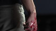 Pan down of man holding bloody knife