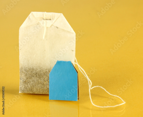 Photo: Tea bag on yellow background Tea bag on yellow background