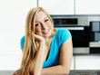 Relaxed young woman standing at the kitchen counter