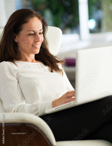 Photo: Happy Mature Woman Working On Laptop Happy Mature Woman Working On Laptop