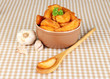 Appetizing village potatoes in bowl on beige tablecloth