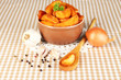 Appetizing village potatoes in bowl on beige tablecloth