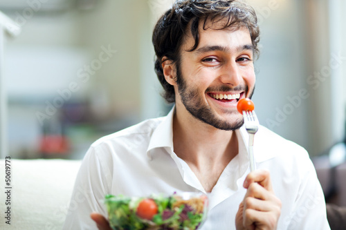 Photo: Happy man eating a salad Happy man eating a salad