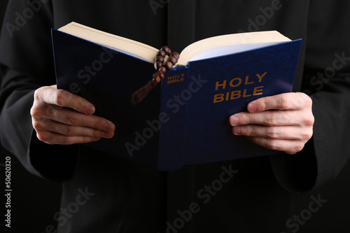 Photo: Priest reading from the holy bible, close up Priest reading from the holy bible, close up