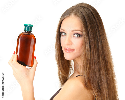 Photo: Woman with long hair holding bottle of shampoo, isolated Woman with long hair holding bottle of shampoo, isolated