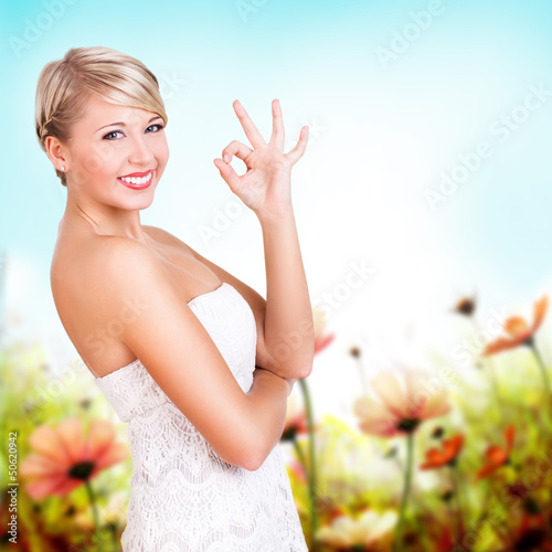Photo: attraktive junge blonde Frau zeigt OK attraktive junge blonde Frau zeigt OK