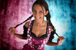 Wunderhübsche Frau im Dirndl vor buntem Hintergrund