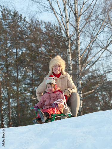 Photo: two-year child sliding downhill on sledge two-year child sliding downhill on sledge
