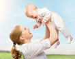 happy family. Mother throws up baby in the sky