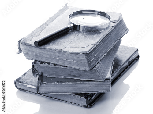 Photo: Magnifying glass and books isolated on white Magnifying glass and books isolated on white