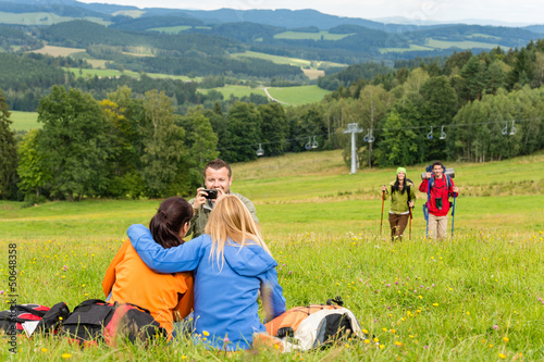 Photo: Hiker with camera taking picture resting friends Hiker with camera taking picture resting friends