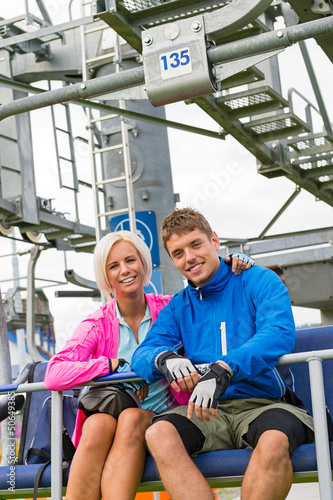 Photo: Smiling couple in sweatsuit sitting char lift Smiling couple in sweatsuit sitting char lift