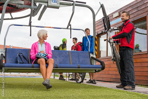 Photo: Happy couple sitting chair lift with bicycle Happy couple sitting chair lift with bicycle