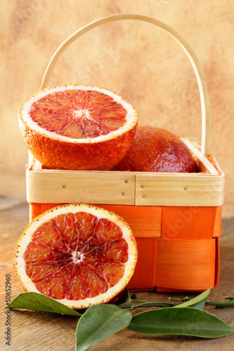 Photo: red (bloody) oranges on a wooden plate red (bloody) oranges on a wooden plate