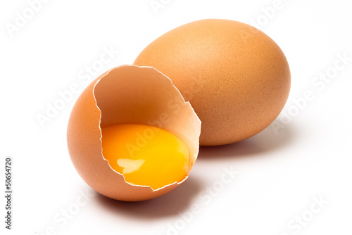 Photo: Two eggs, one broken, with shadow isolated on white background Two eggs, one broken, with shadow isolated on white background