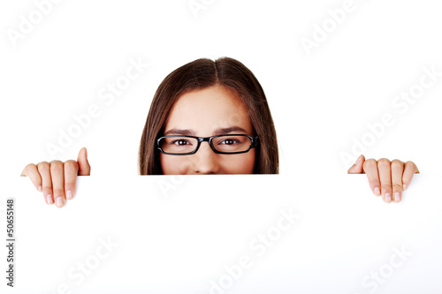 Photo: Portrait young happy woman with blank board Portrait young happy woman with blank board