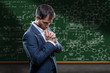 Scientist in front of chalk board in deep thought