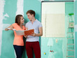 Foto: Young couple checking the plans of their building lot Young couple checking the plans of their building lot