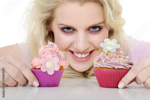 Photo: Junge hübsche Frau mit Cupcake lacht Junge hübsche Frau mit Cupcake lacht