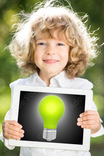 Photo: Child holding tablet PC with lightbulb Child holding tablet PC with lightbulb