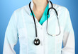 Medical doctor with stethoscope, on color background