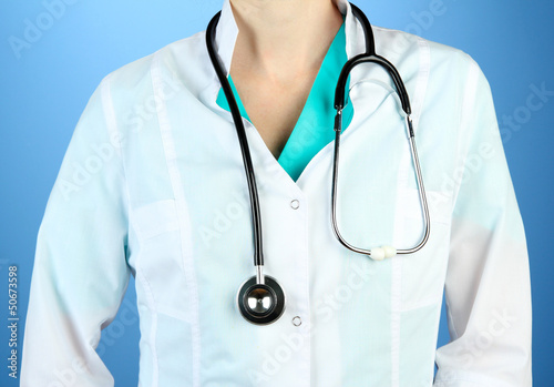 Photo: Medical doctor with stethoscope, on color background Medical doctor with stethoscope, on color background