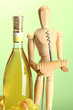 Mannequin with corkscrew and wine bottle, on green background