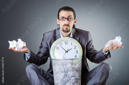 Photo: Man with clock and pile of papers Man with clock and pile of papers