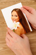 Photos in hands on wooden table