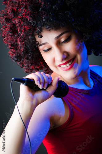 Photo: Female performer at disco with mic Female performer at disco with mic