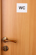 Toilet sign on wooden door