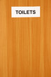 Toilet sign on wooden background