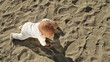 Baby crawling on sand, steadicam above