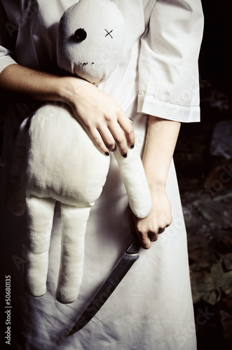 Photo: Horror style shot: moppet doll and knife in someone's hands Horror style shot: moppet doll and knife in someone's hands