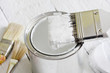 Paint brush and can on white planks