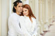 Dark-haired man and red-haired woman stand embraced