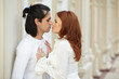 Dark-haired man and red-haired woman stand, touching noses