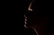 Beautiful girl head slightly lit in dark