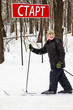 Smiling boy on skis at sign start at start point of ski race