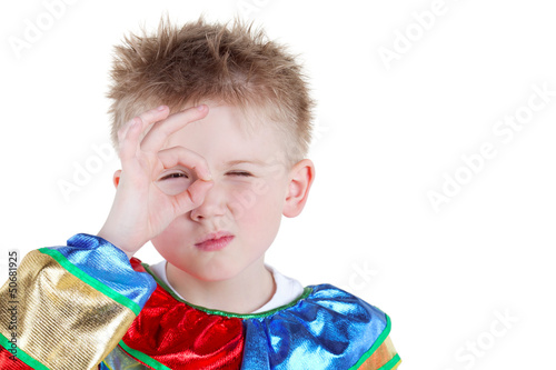 Photo: Little boy in carnival suit looks through ring made of thumb Little boy in carnival suit looks through ring made of thumb