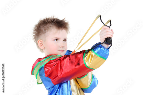 Photo: Boy in clown costume holds slingshot and aims up isolated Boy in clown costume holds slingshot and aims up isolated