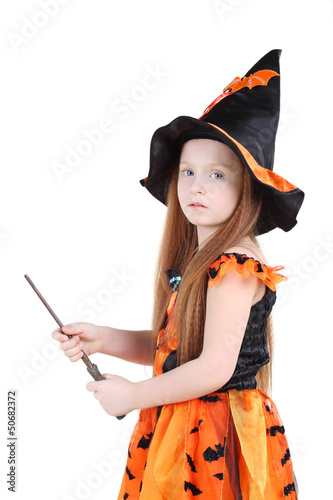 Photo: Girl in orange costume of witch for Halloween holds wand Girl in orange costume of witch for Halloween holds wand